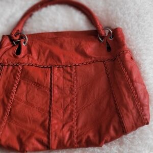 Chic Jessica Simpson shoulder bag in vibrant red. Features sleek design and gold